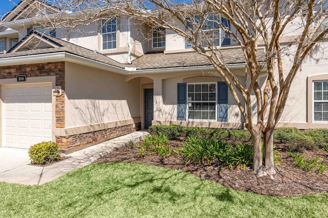 view of front of home featuring stucco siding, stone siding, a garage, and roof with shingles