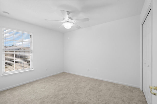 empty room with carpet, baseboards, and ceiling fan