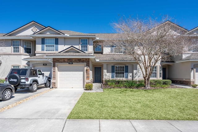 view of property with stucco siding, a front lawn, driveway, an attached garage, and a balcony