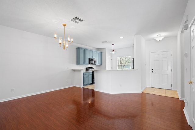 unfurnished living room featuring visible vents, baseboards, light wood-style floors, and a notable chandelier