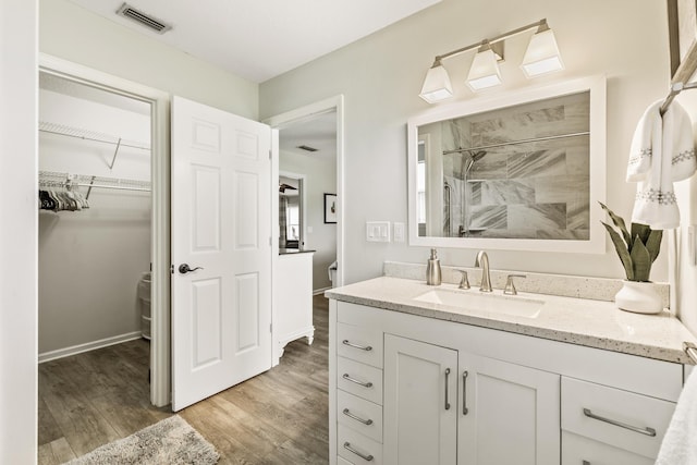 2077 W Lymington Way, Saint Augustine, FL 32084 - bathroom with toilet, vanity, wood finished floors, tiled shower, and a walk in closet