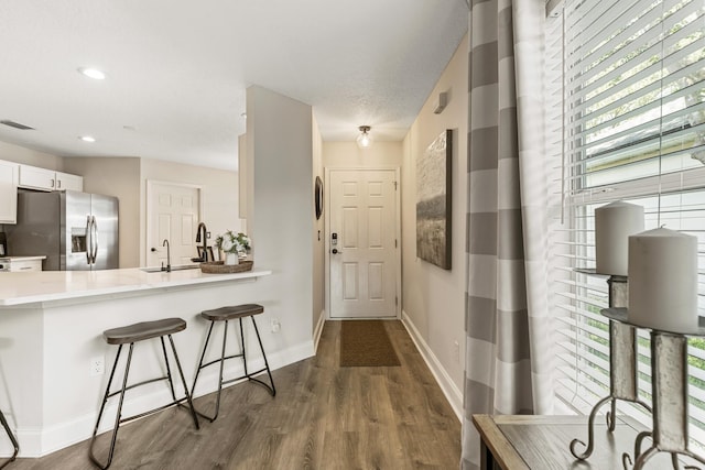 2077 W Lymington Way, Saint Augustine, FL 32084 - hallway featuring healthy amount of natural light, dark wood-style floors, baseboards, recessed lighting, and a sink