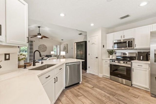2077 W Lymington Way, Saint Augustine, FL 32084 - kitchen featuring appliances with stainless steel finishes, a sink, white cabinetry, a peninsula, and ceiling fan