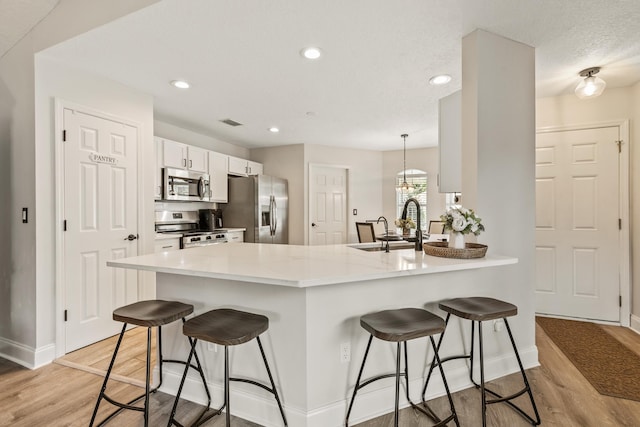 2077 W Lymington Way, Saint Augustine, FL 32084 - kitchen featuring stainless steel appliances, a breakfast bar, light wood finished floors, a sink, and recessed lighting