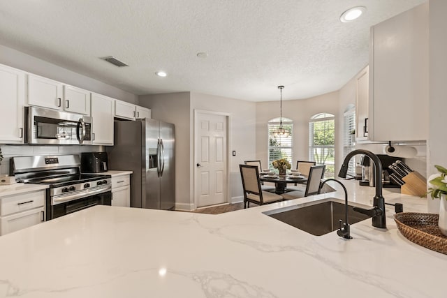 2077 W Lymington Way, Saint Augustine, FL 32084 - kitchen featuring stainless steel appliances, a sink, white cabinets, recessed lighting, and hanging light fixtures