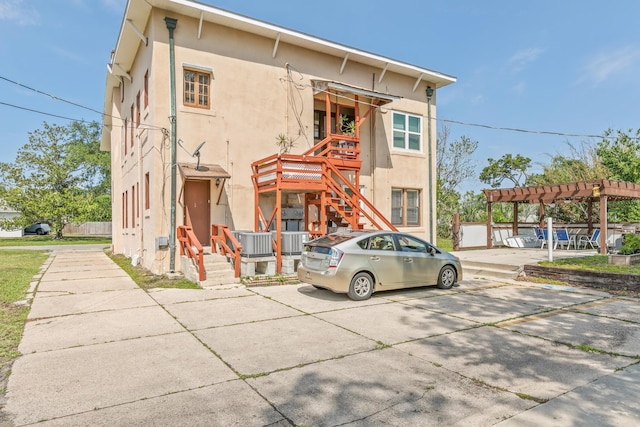 85 N Saint Augustine Blvd Unit 1, Saint Augustine, FL 32080 - view of front of home with stucco siding, stairway, a pergola, and uncovered parking