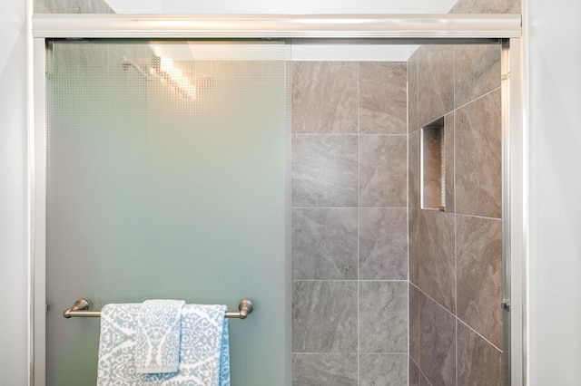 bathroom with a shower with door