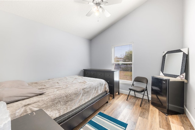 bedroom featuring light hardwood / wood-style flooring, vaulted ceiling, and ceiling fan