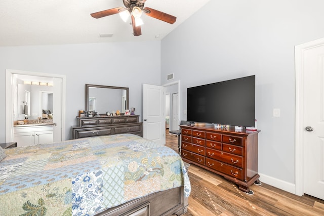 bedroom with vaulted ceiling, ceiling fan, light hardwood / wood-style floors, and ensuite bath