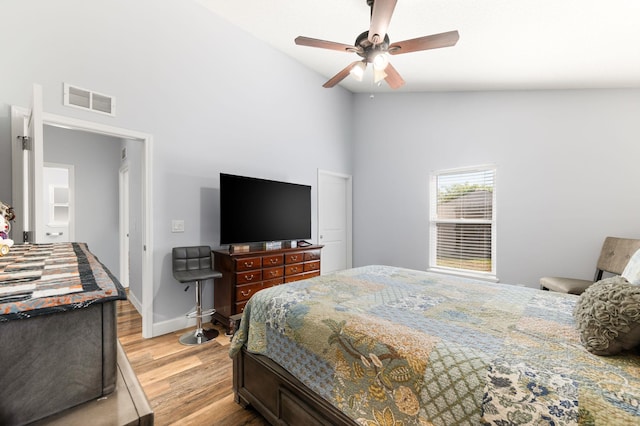 bedroom featuring light wood-type flooring, high vaulted ceiling, and ceiling fan