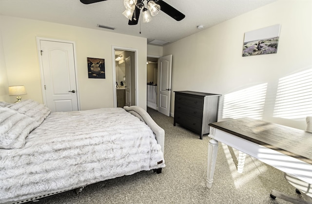 carpeted bedroom with a textured ceiling, visible vents, and a ceiling fan