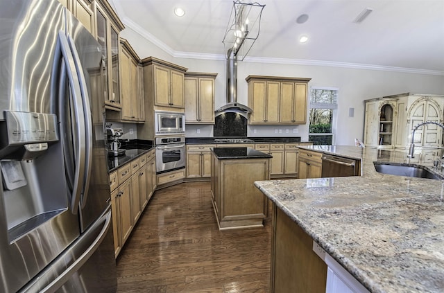 kitchen featuring hanging light fixtures, appliances with stainless steel finishes, glass insert cabinets, a sink, and wall chimney exhaust hood