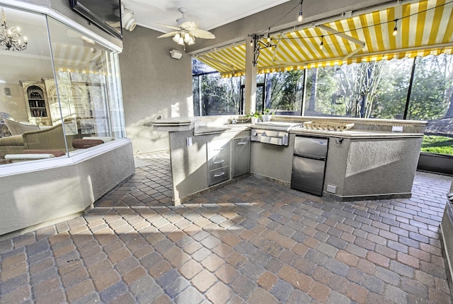 view of patio with an outdoor kitchen and a ceiling fan