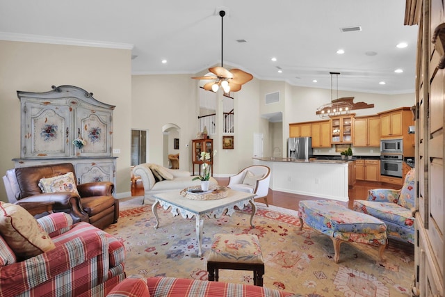 kitchen with a large island with sink, arched walkways, dark wood finished floors, dishwasher, and a chandelier