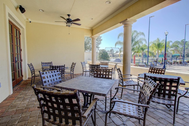 view of patio with outdoor dining space, french doors, fence, and a ceiling fan