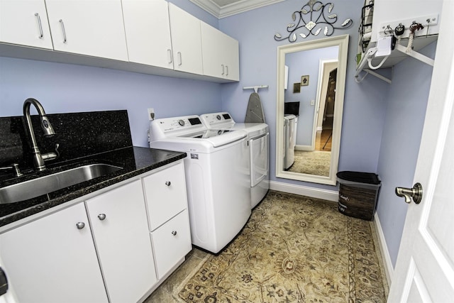 laundry area with a sink, baseboards, ornamental molding, independent washer and dryer, and cabinet space