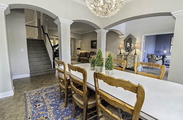 dining area with baseboards, arched walkways, stairs, crown molding, and ornate columns