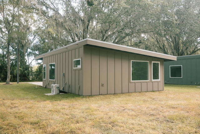 view of side of property featuring a lawn and ac unit