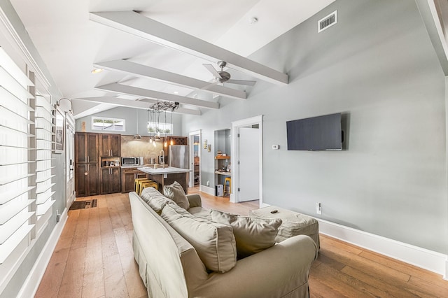 living room with lofted ceiling with beams, light hardwood / wood-style floors, and ceiling fan