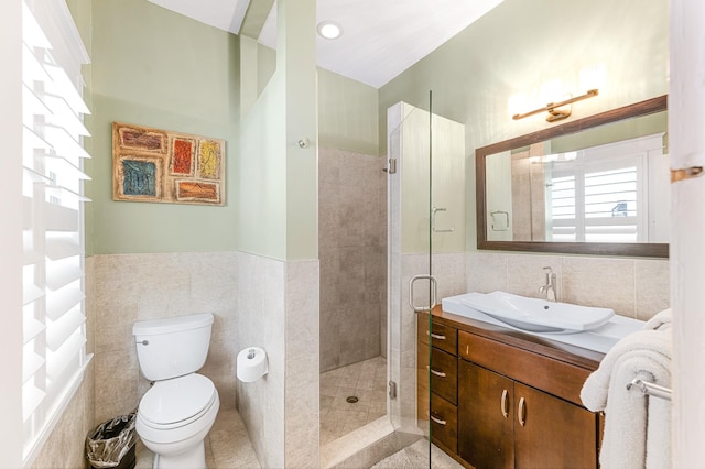 bathroom with walk in shower, vanity, toilet, and tile walls