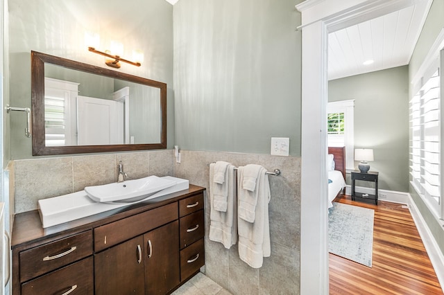 bathroom featuring hardwood / wood-style flooring, vanity, and tile walls