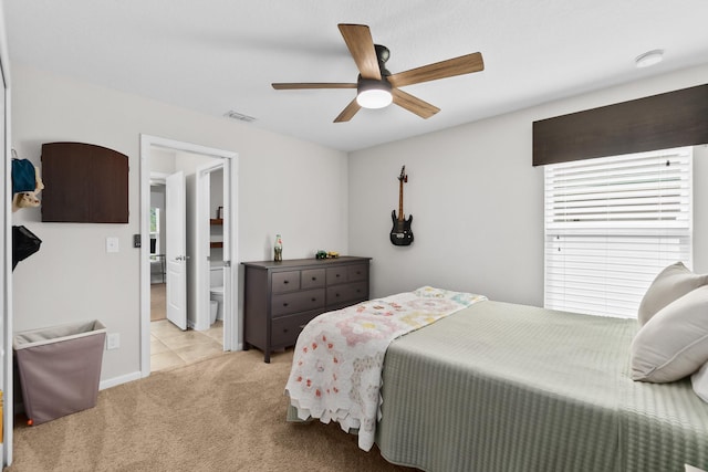 carpeted bedroom with ceiling fan and ensuite bath