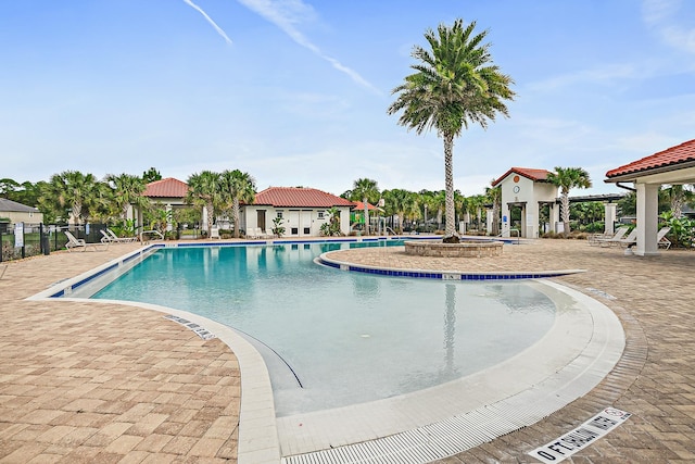 pool with a patio and fence