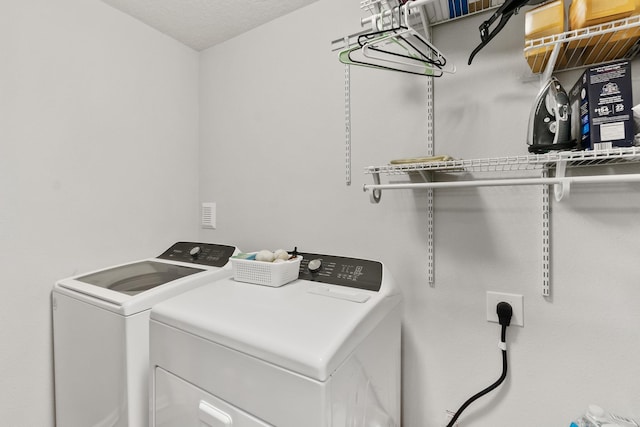 clothes washing area with washer and clothes dryer