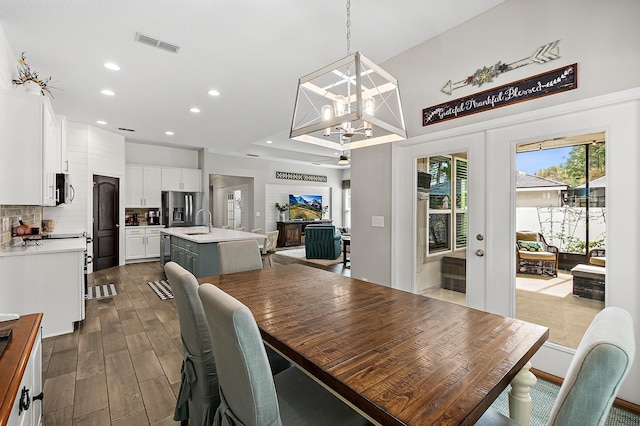 dining space featuring visible vents, dark wood-type flooring, a chandelier, recessed lighting, and french doors