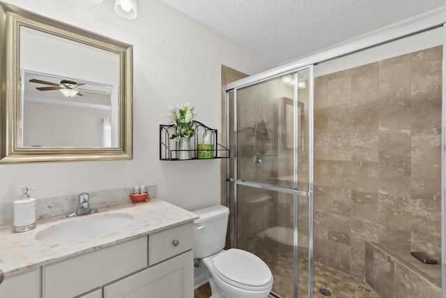 full bathroom with toilet, a stall shower, vanity, and a textured ceiling