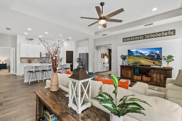 living area featuring recessed lighting, visible vents, wood finished floors, and a ceiling fan