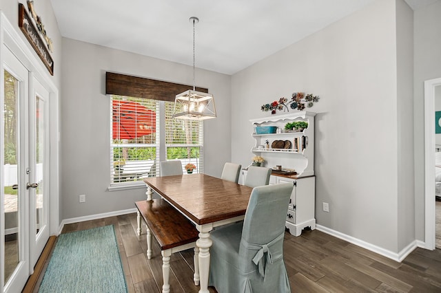 dining space with dark hardwood / wood-style floors, a chandelier, and french doors