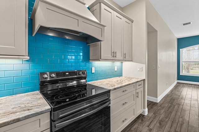 kitchen with black range with electric stovetop, custom exhaust hood, baseboards, dark wood-style flooring, and decorative backsplash