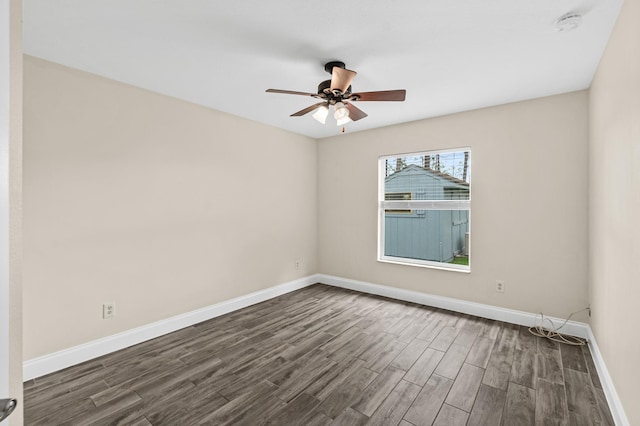 empty room with dark wood finished floors, baseboards, ceiling fan, and a smoke detector