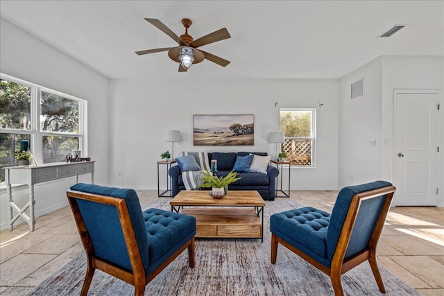 living room featuring ceiling fan and a textured ceiling