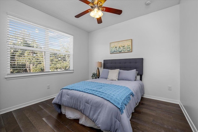 bedroom with dark hardwood / wood-style flooring and ceiling fan