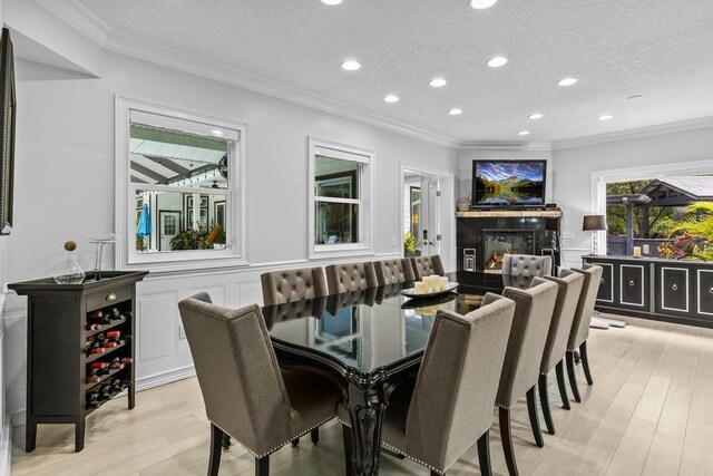 living room featuring a skylight, ceiling fan, a towering ceiling, and light hardwood / wood-style floors