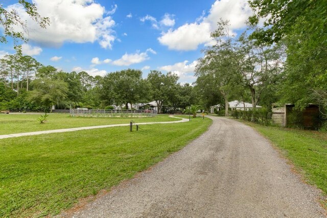 view of property's community with a lawn and a storage unit