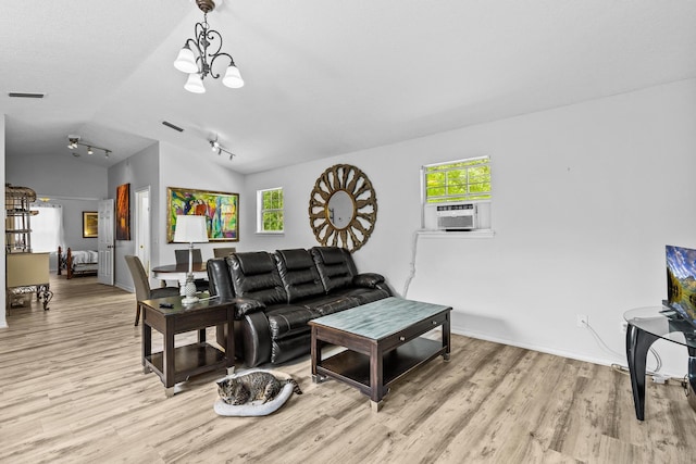 living room with a notable chandelier, cooling unit, lofted ceiling, and light wood-type flooring