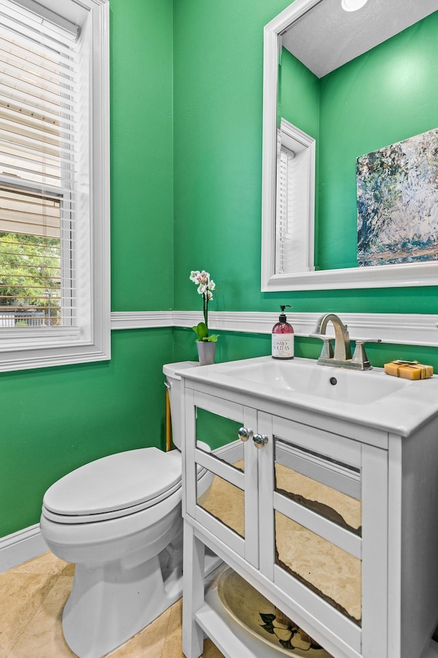 bathroom featuring tile patterned flooring, vanity, and toilet