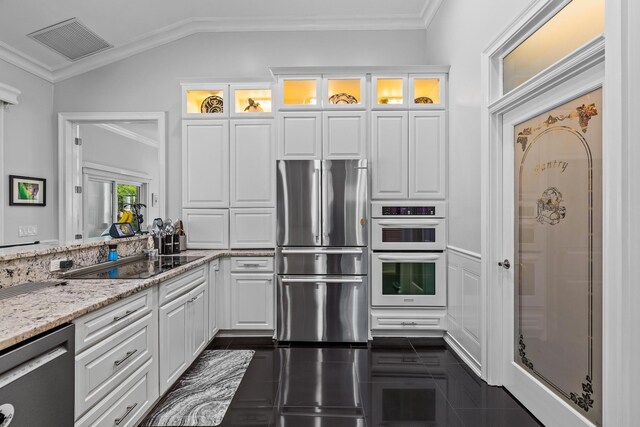 kitchen featuring black electric cooktop, white cabinetry, ornamental molding, and light stone counters