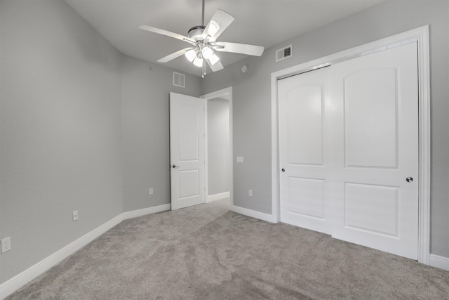 unfurnished bedroom with ceiling fan, a closet, and light carpet