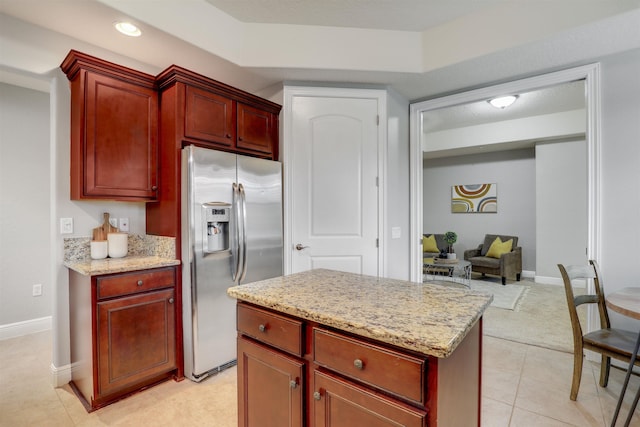 kitchen featuring light stone counters, stainless steel fridge with ice dispenser, and light tile patterned floors