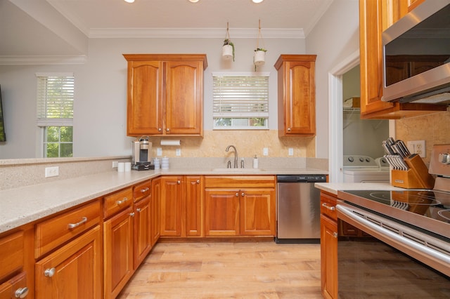 2 Lisbon St, Saint Augustine, FL 32080 - kitchen featuring appliances with stainless steel finishes, independent washer and dryer, light wood-style floors, light countertops, and backsplash