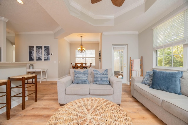 2 Lisbon St, Saint Augustine, FL 32080 - living area featuring light wood-style floors, ornamental molding, a chandelier, a raised ceiling, and baseboards