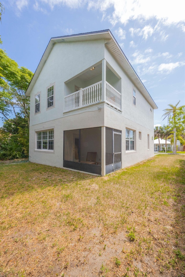 2 Lisbon St, Saint Augustine, FL 32080 - rear view of property with a balcony, a yard, stucco siding, and a sunroom