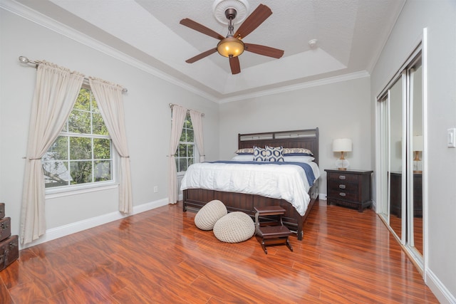 2 Lisbon St, Saint Augustine, FL 32080 - bedroom with wood finished floors, a tray ceiling, ornamental molding, baseboards, and ceiling fan