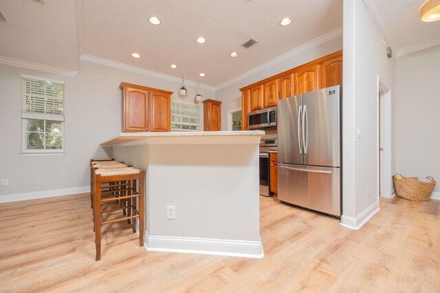 2 Lisbon St, Saint Augustine, FL 32080 - kitchen featuring appliances with stainless steel finishes, a kitchen bar, light wood finished floors, a peninsula, and recessed lighting