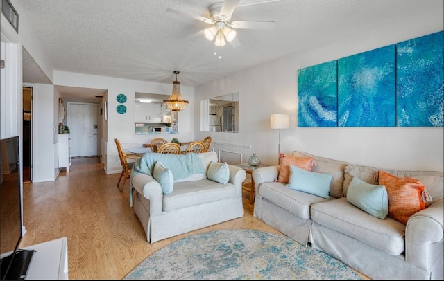 880 A1A Beach Blvd, Saint Augustine Beach, FL 32080 - living room featuring a ceiling fan, visible vents, light wood-style flooring, baseboards, and a textured ceiling