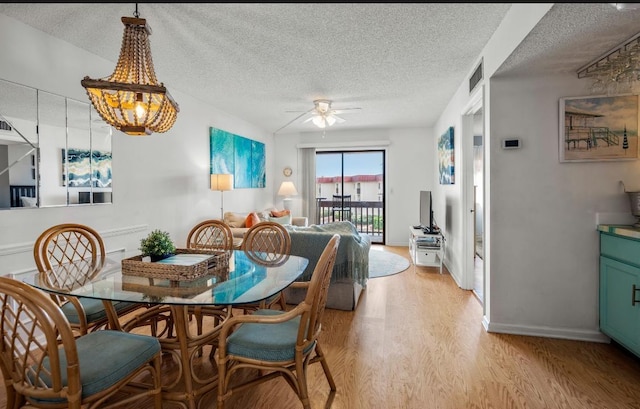 880 A1A Beach Blvd, Saint Augustine Beach, FL 32080 - dining space featuring light wood finished floors, visible vents, baseboards, a textured ceiling, and ceiling fan with notable chandelier